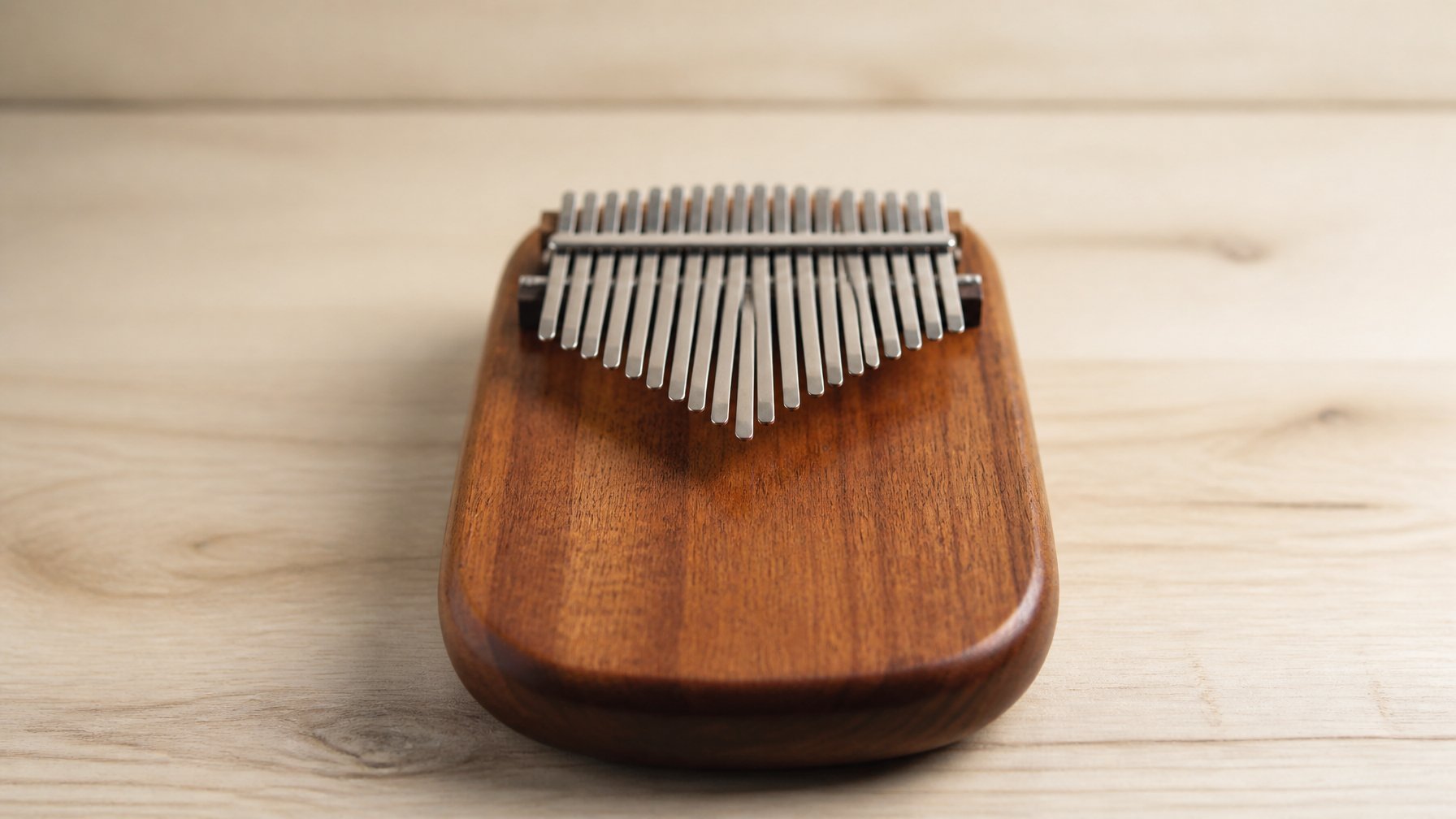 A kalimba musical instrument resting on a wooden table with a blurred neutral background.